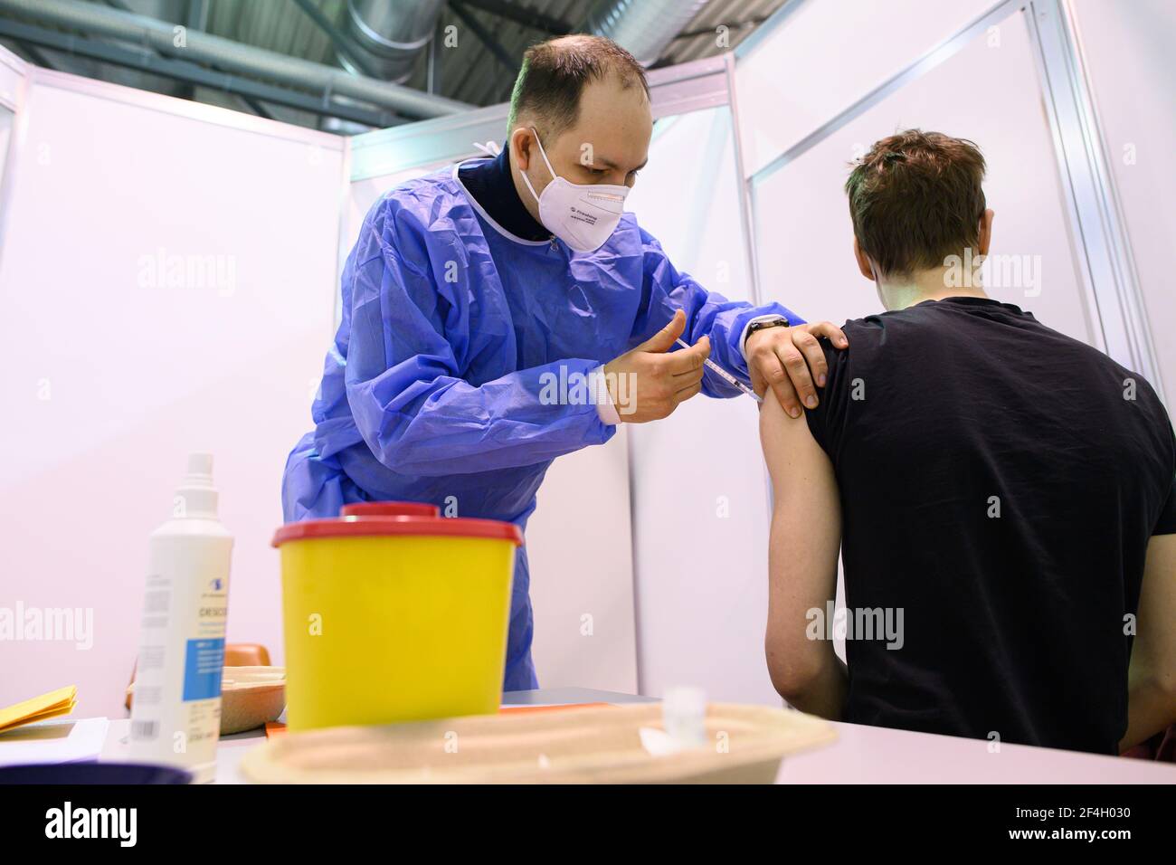 Dresden, Germany. 20th Mar, 2021. A doctor inoculates a man against the coronavirus at a vaccination centre in Dresden, Germany, on Saturday. Germany's hopes of relaxing its lockdown restrictions in time for Easter holidays at the start of April are dwindling amid a renewed surge in infection rates on Sunday. Credit: Robert Michael/dpa-Zentralbild/dpa/Alamy Live News Stock Photo