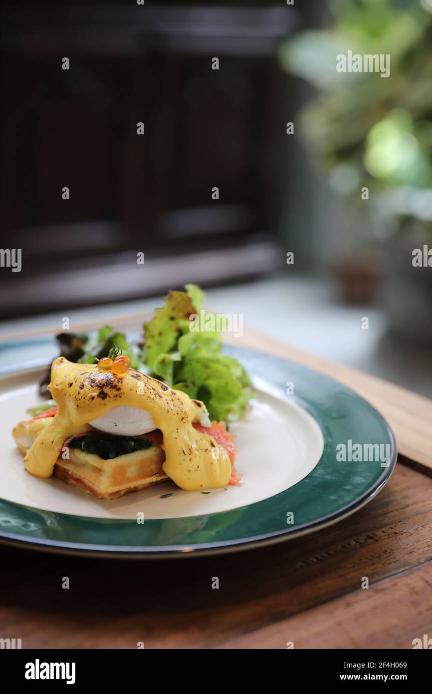 Breakfast food egg benedict , poached egg with yellow sauce with waffle
