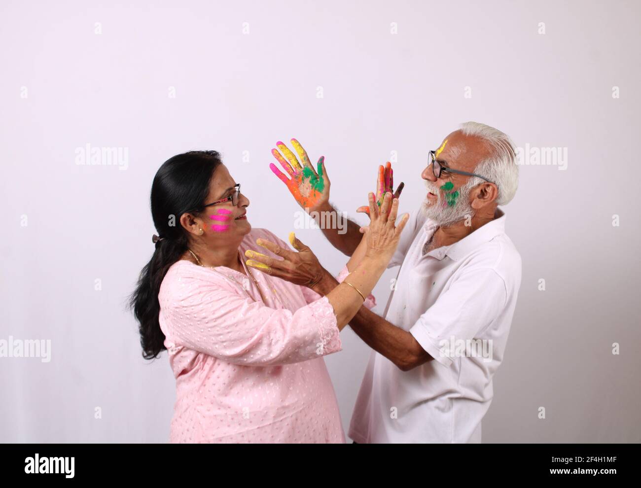 indian senior or old aged couple celebrating holi with colour Stock Photo