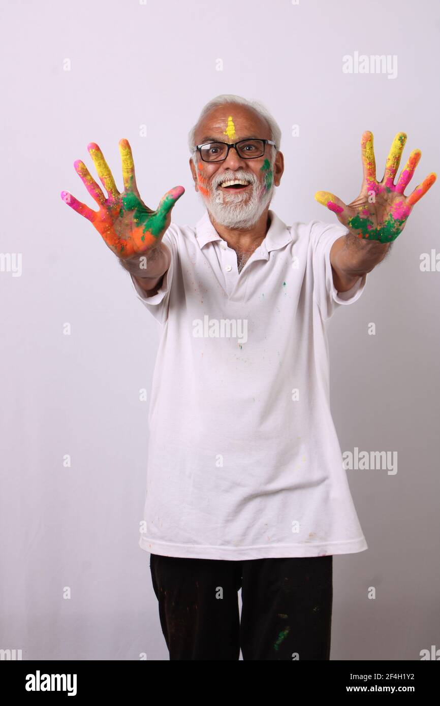 Indian senior or old man celebrating holi festival of colours. Stock Photo