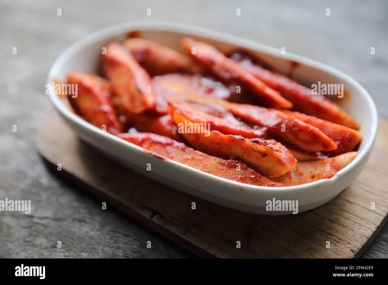 Traditional German currywurst pieces of sausage with curry sauce on