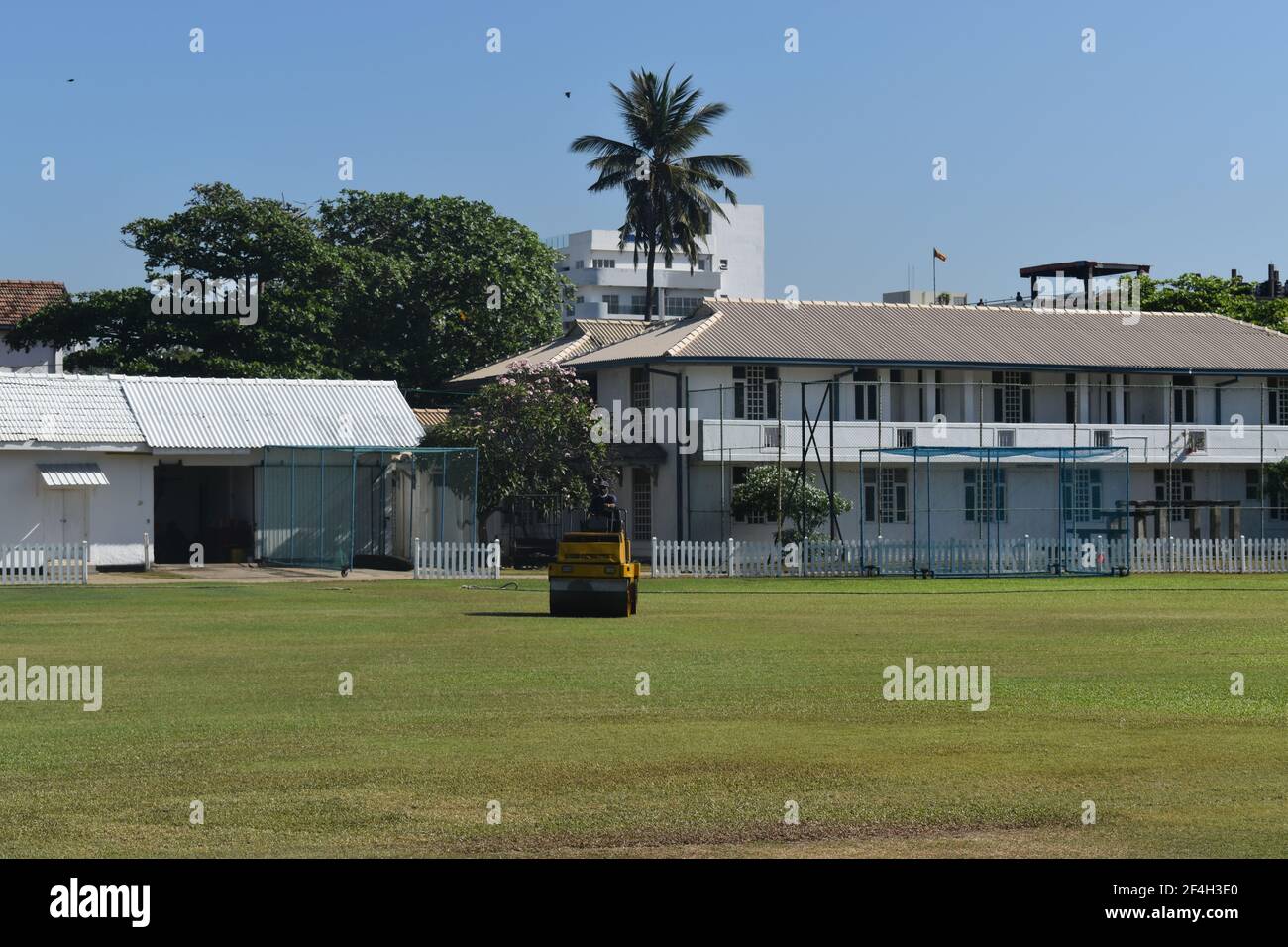 A roller machine in action. Ground staff preparing the turf wicket and ground for a cricket match at the picturistic school cricket ground. St. Thomas College, Mt. Lavinia. Colombo. Sri Lanka. Stock Photo
