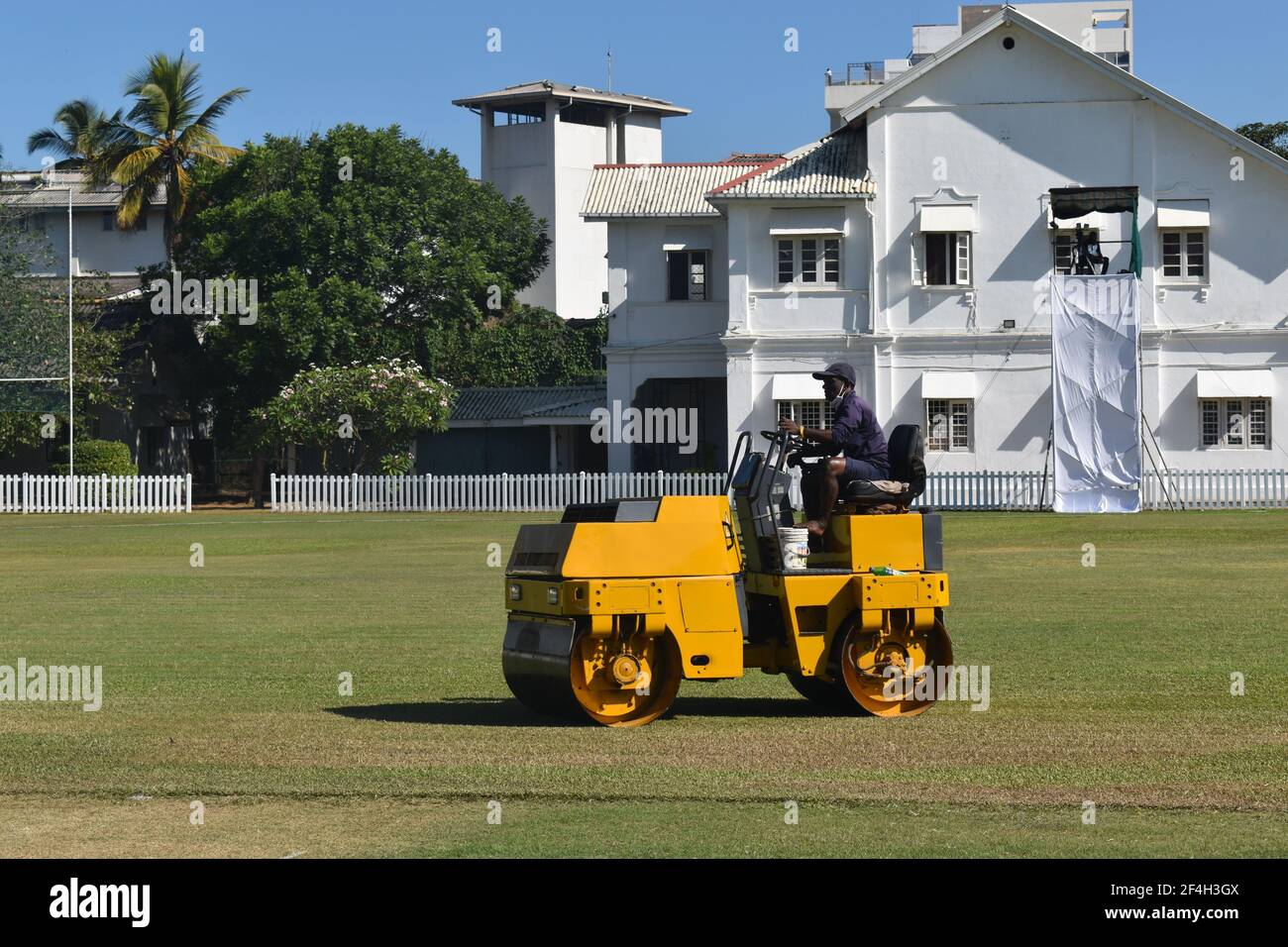 A roller machine in action. Ground staff preparing the turf wicket and ground for a cricket match at the picturistic school cricket ground. St. Thomas College, Mt. Lavinia. Colombo. Sri Lanka. Stock Photo