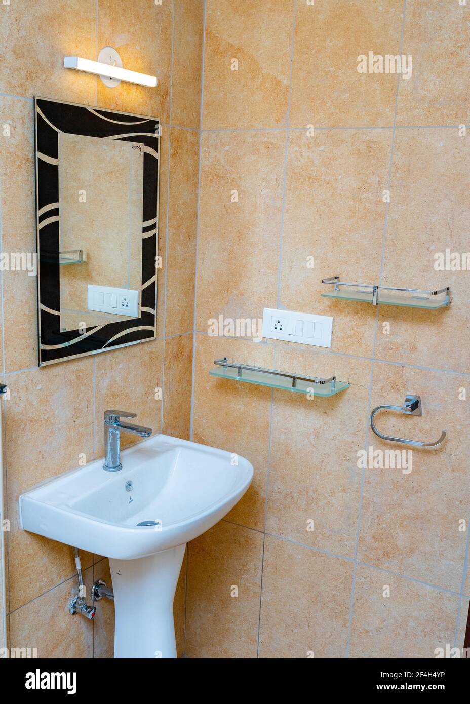 A white pedestal washbasin and black-framed mirror - bathroom ...