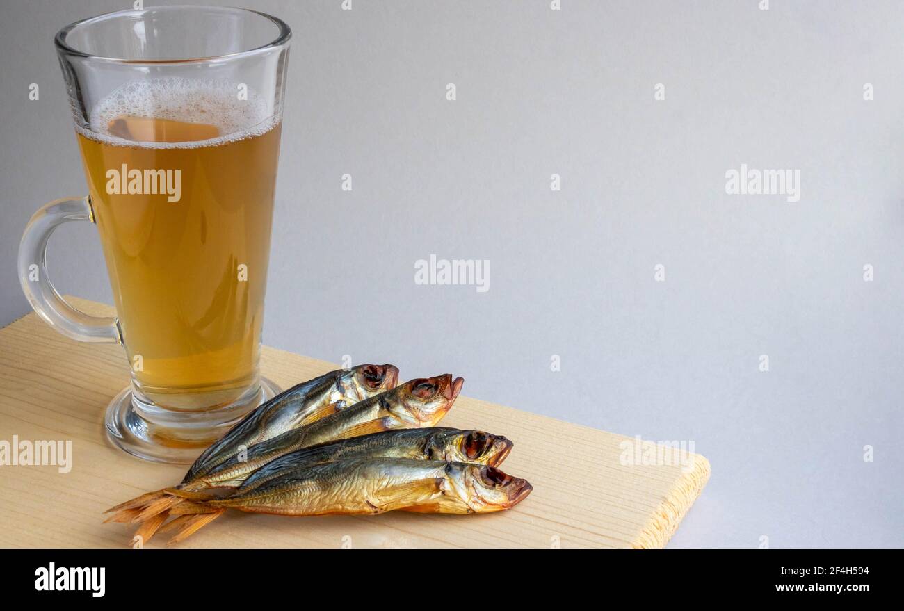 Beer in a glass and smoked fish. Scales and measuring tape are nearby. On  pine boards. A day without diets Stock Photo - Alamy