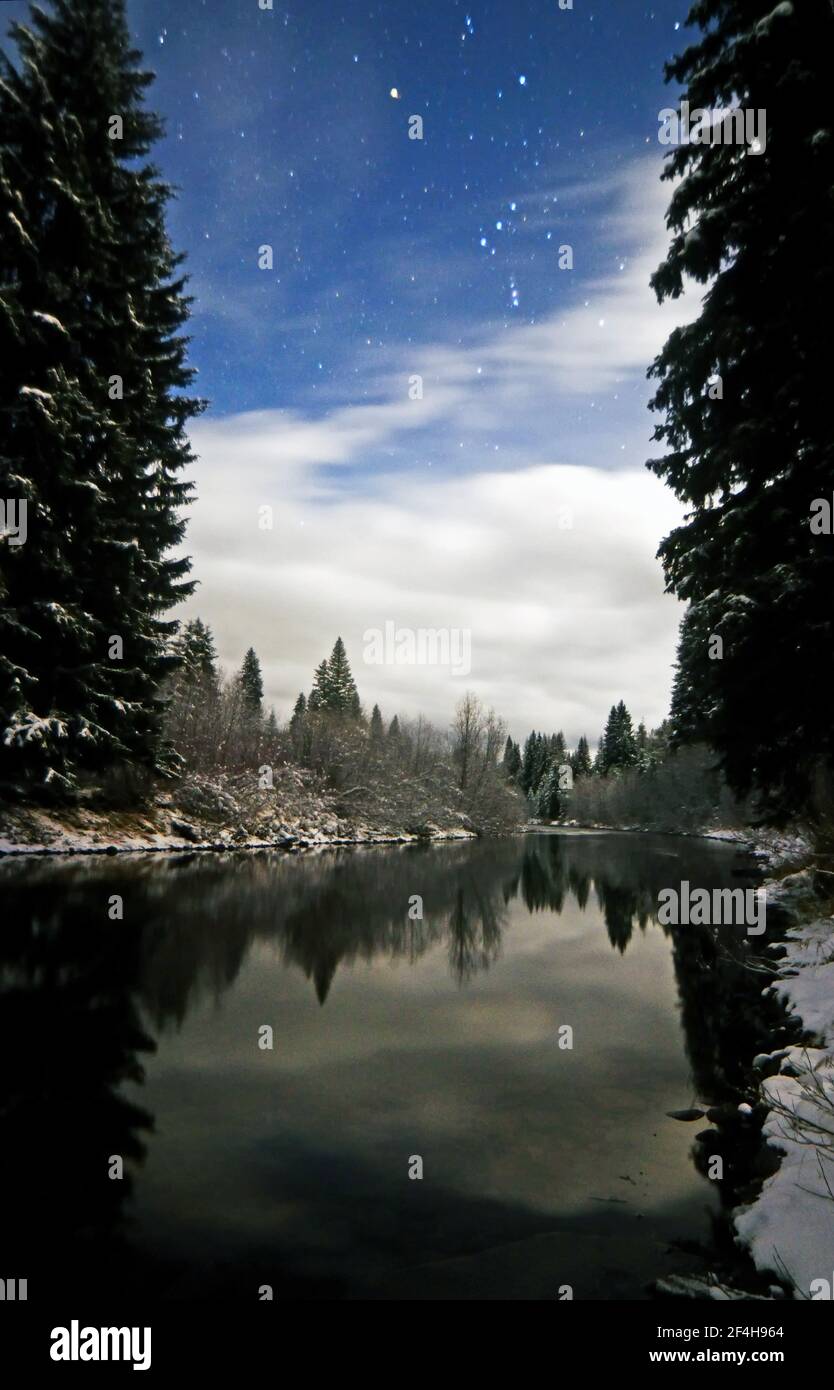 Yaak River at night by moonlight with Orion in the sky. Yaak Valley, northwest Montana. (Photo by Randy Beacham) Stock Photo