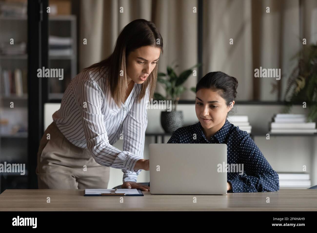 Multiracial female colleagues brainstorm on laptop in office Stock ...