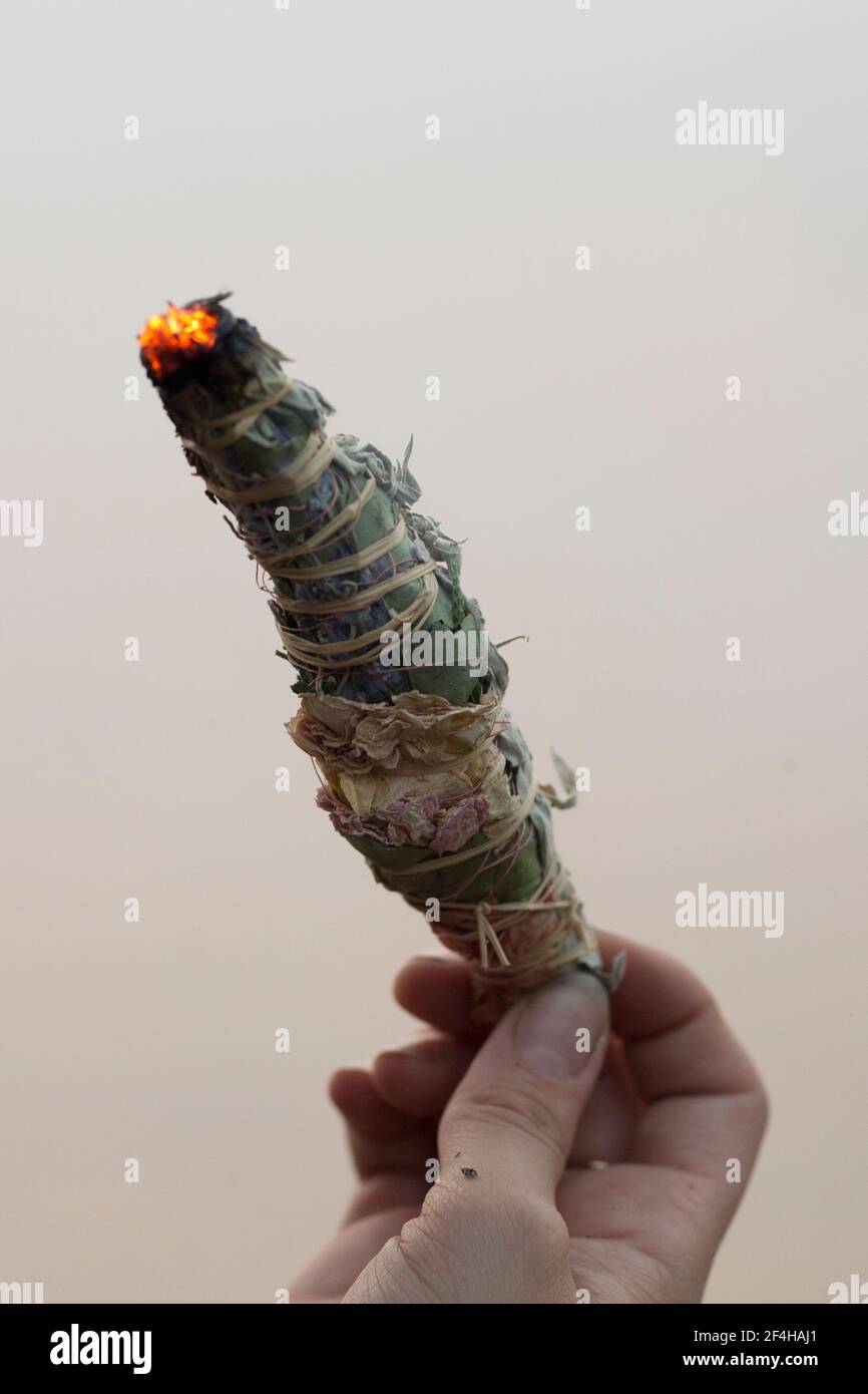 smudge stick burning in a hand Stock Photo