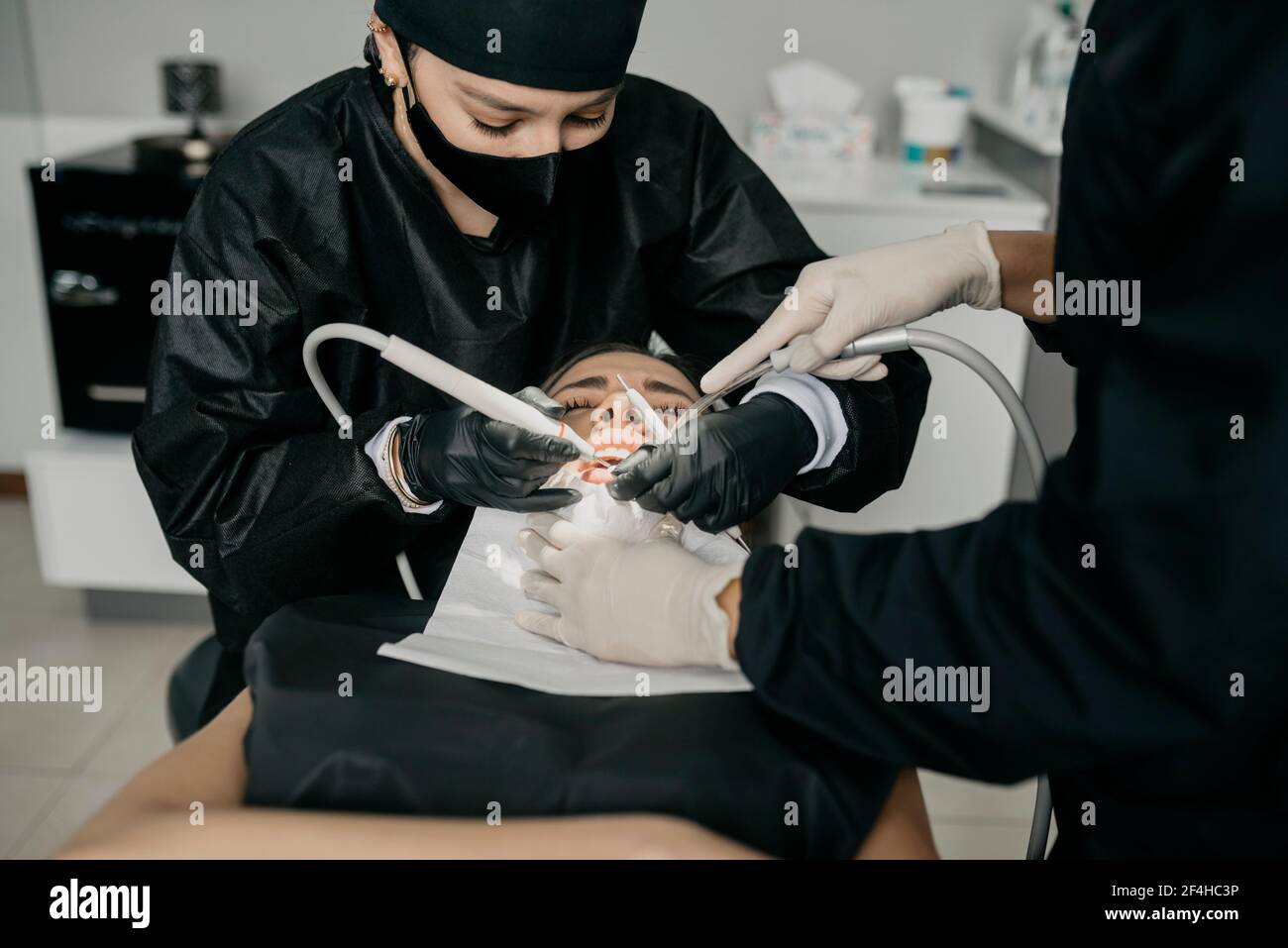From above of dentists with dental drill and air water syringe making ...