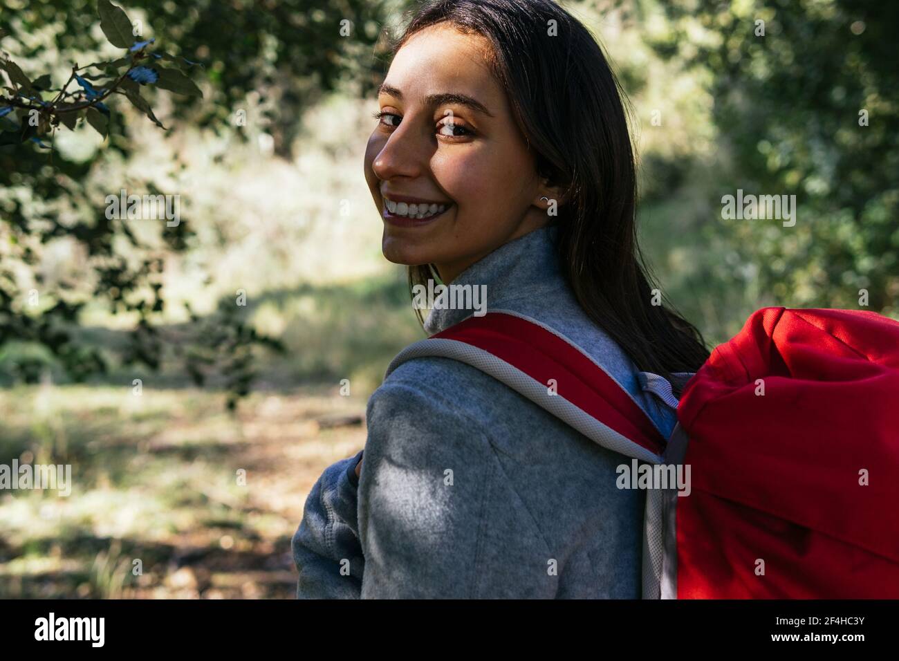 Back view of happy optimistic young female hiker in activewear with ...