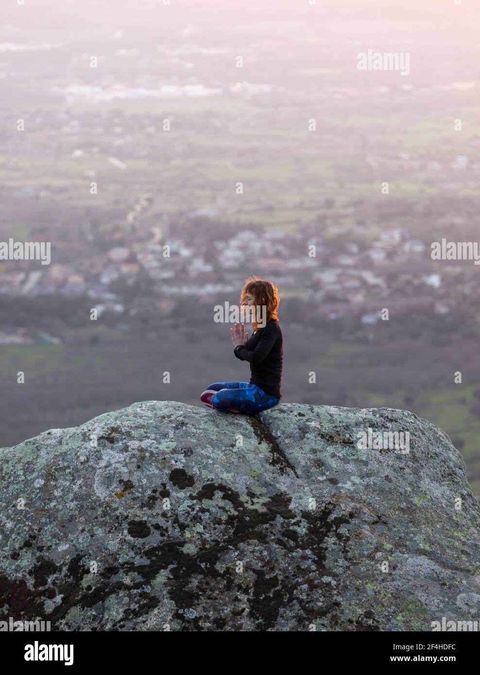 Tranquil female meditating on rocky hi-res stock photography and images ...