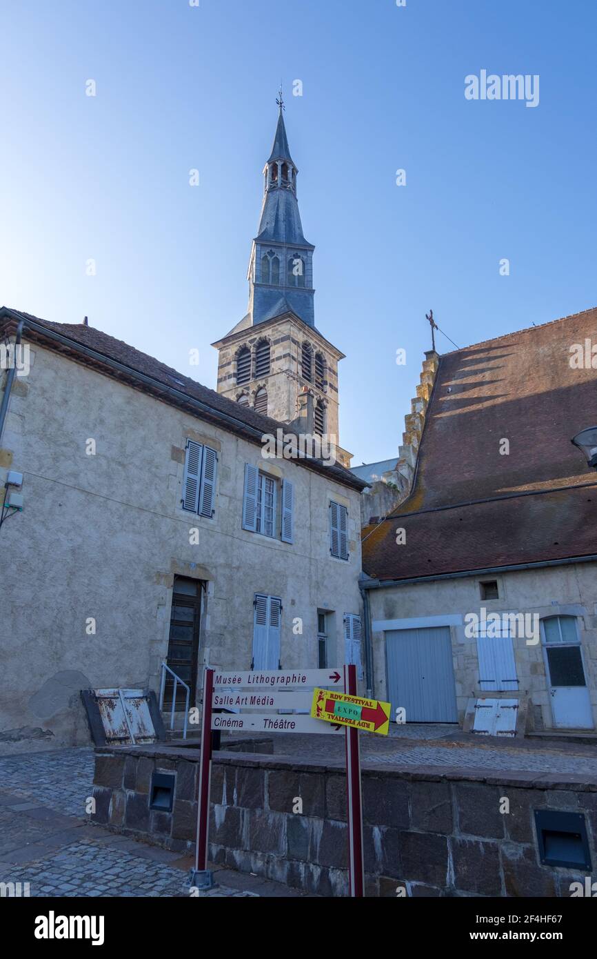 St Pourcain Sur Sioule, France - August 22, 2019: Bell tower of the Sainte Croix church and Houses surrounding the Benedictine courtyard in Saint-Pour Stock Photo