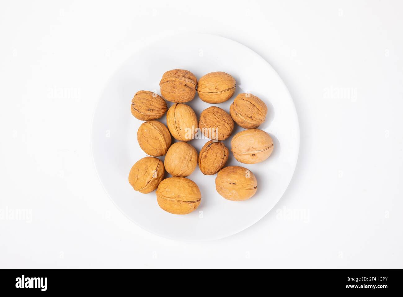 A top view of walnuts on the plate isolated on white background Stock ...