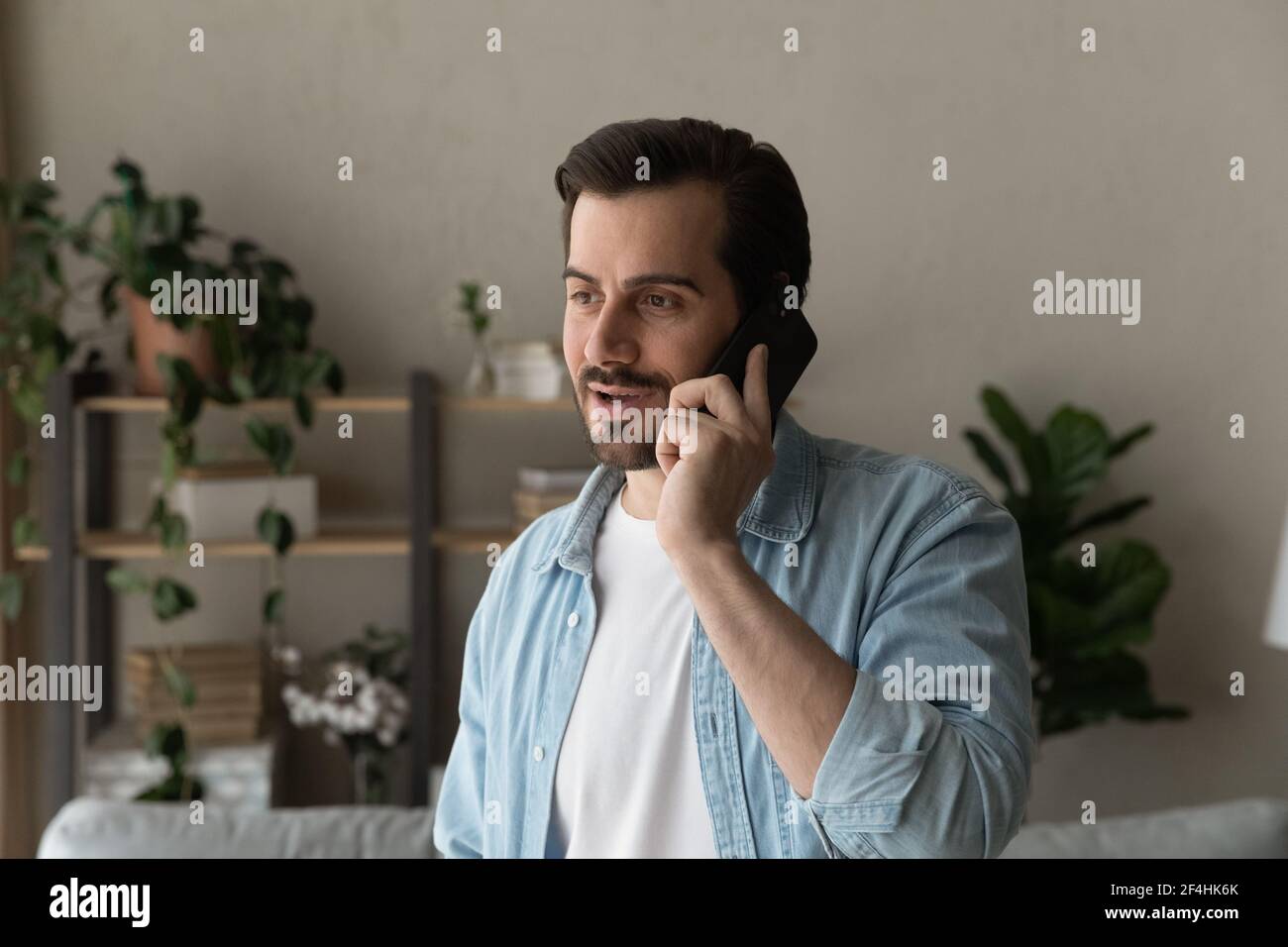 Close up man talking on phone, enjoying pleasant conversation Stock Photo