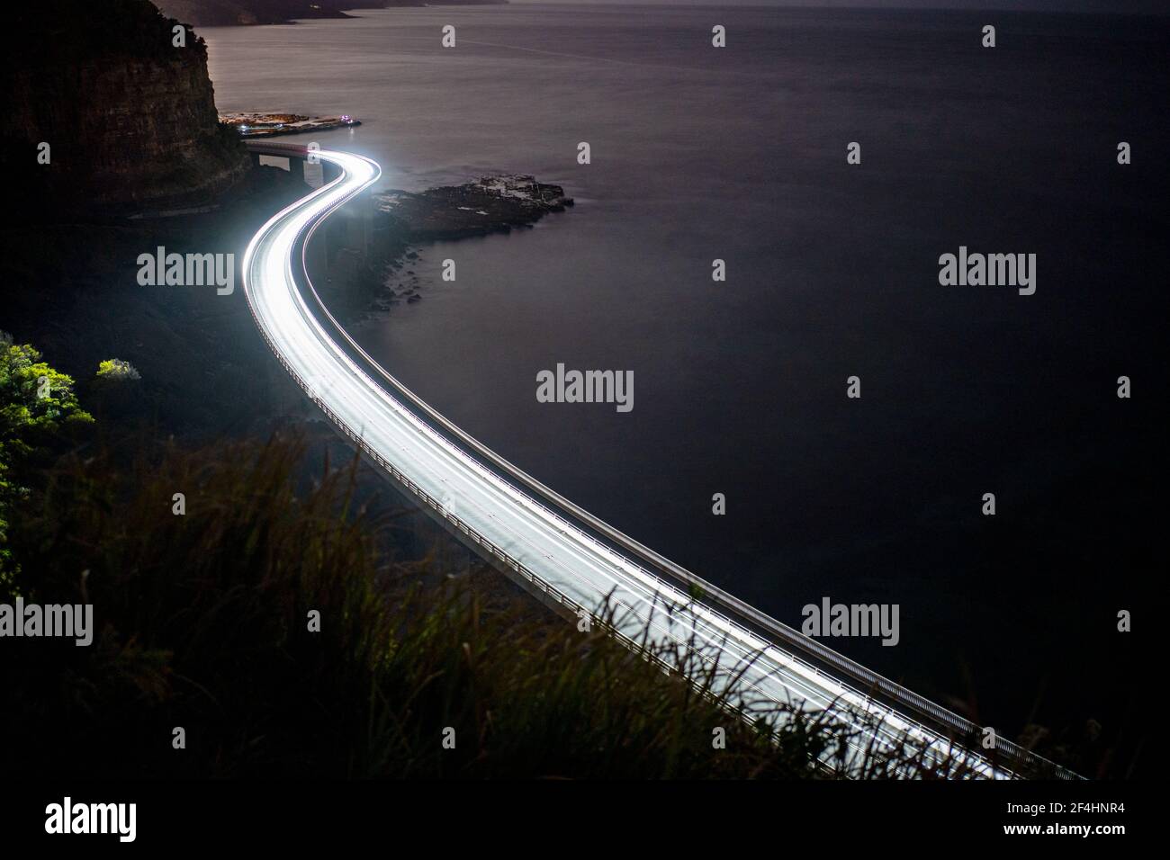 White light trail long exposure photography on a bridge at the sea cliff bridge Stock Photo