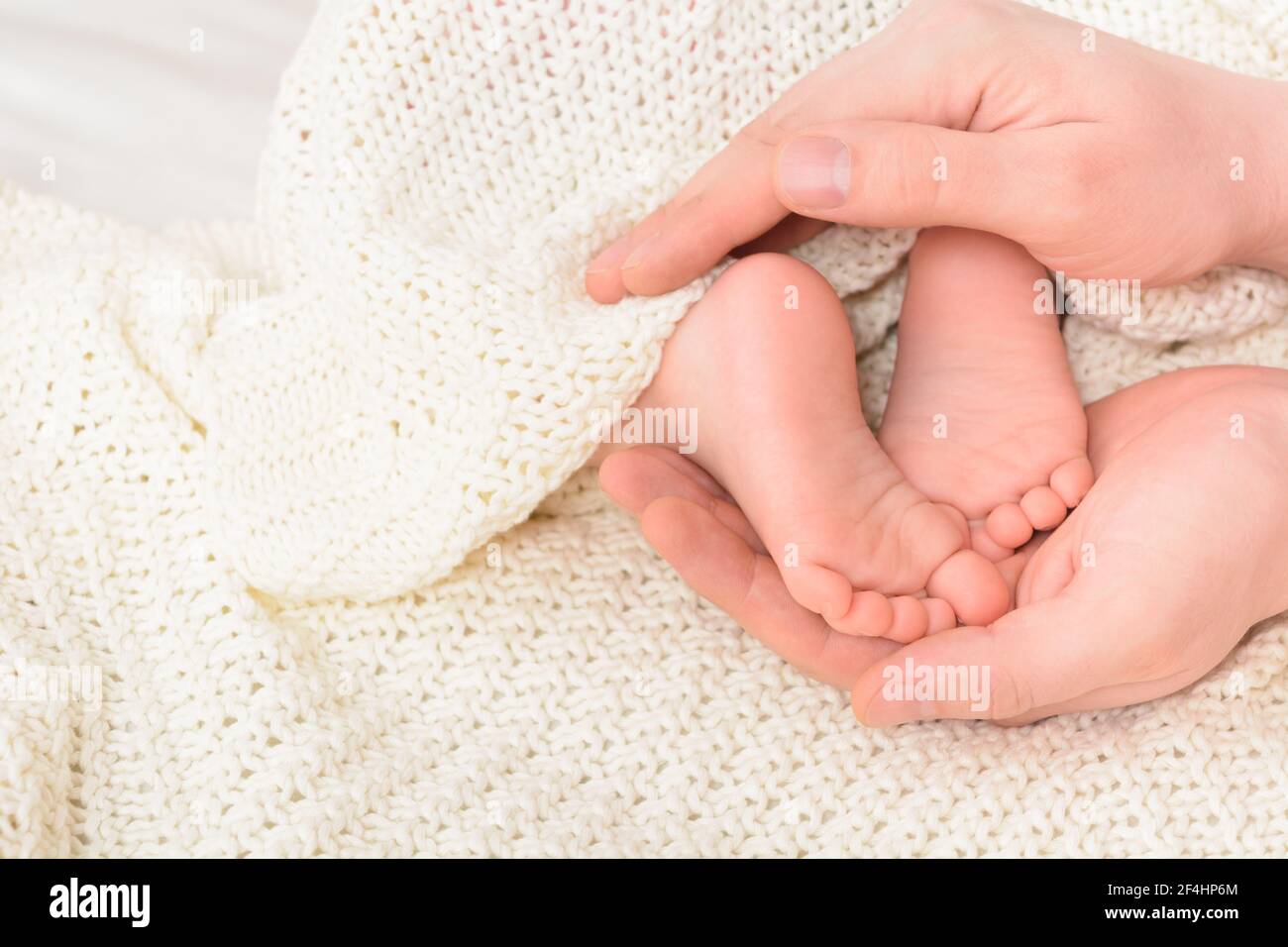 Baby feet in male hands with soft background, close-up. Father's day concept Stock Photo