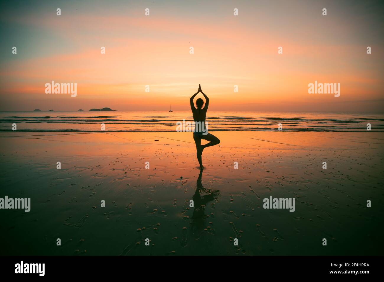 Silhouette of young yoga woman on the beach at amazing sunset Stock ...