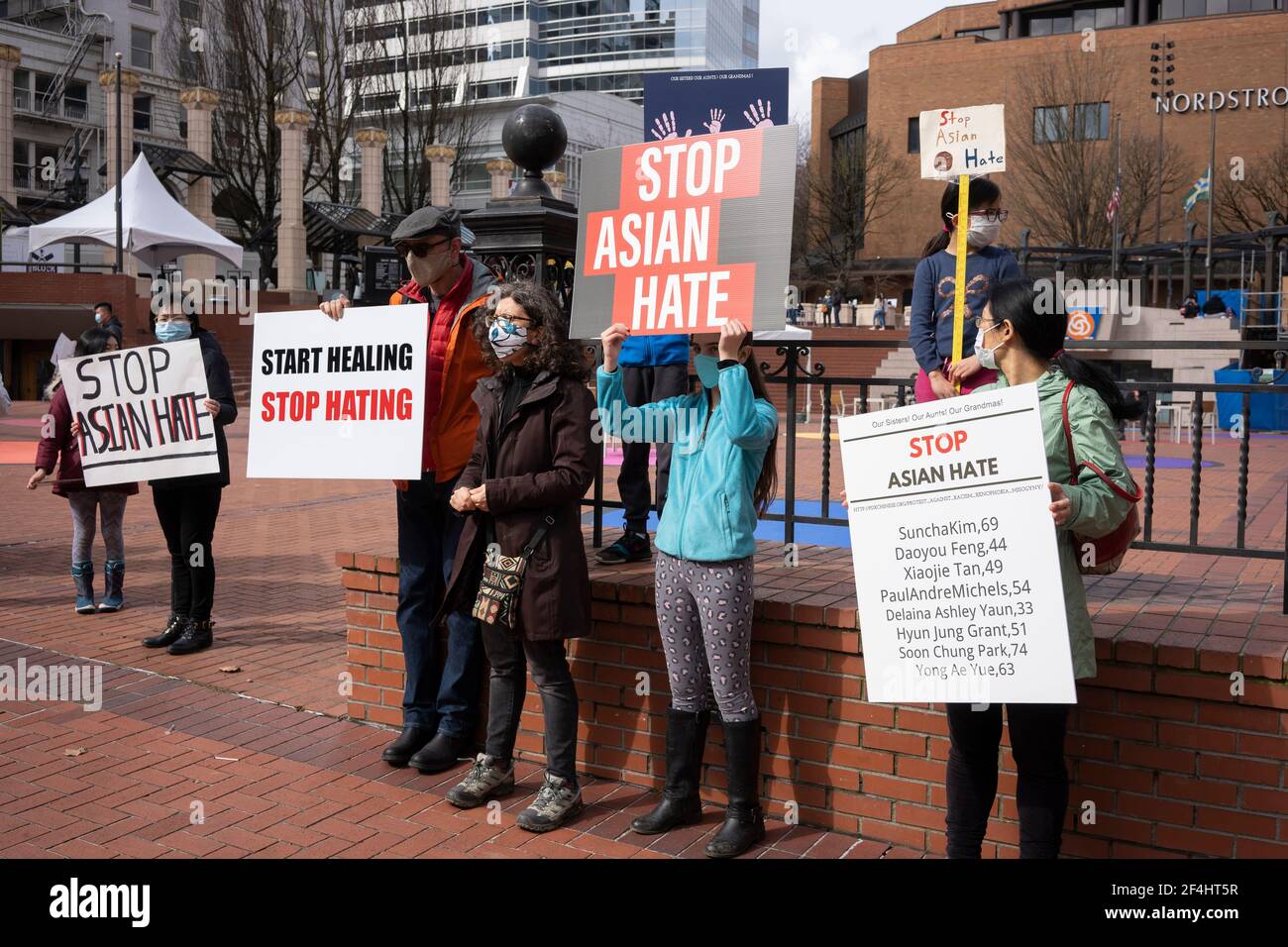 Peaceful demonstrators are seen in downtown Portland's Pioneer Courthouse Square denouncing violence against Asian Americans on Sunday, March 21, 2021. Stock Photo