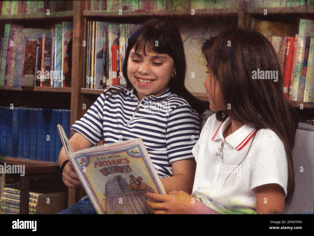 Girls practicing Reading to each other in Walnut Creek Elementary School library  1996  MODEL RELEASE  ET-315-318. Stock Photo
