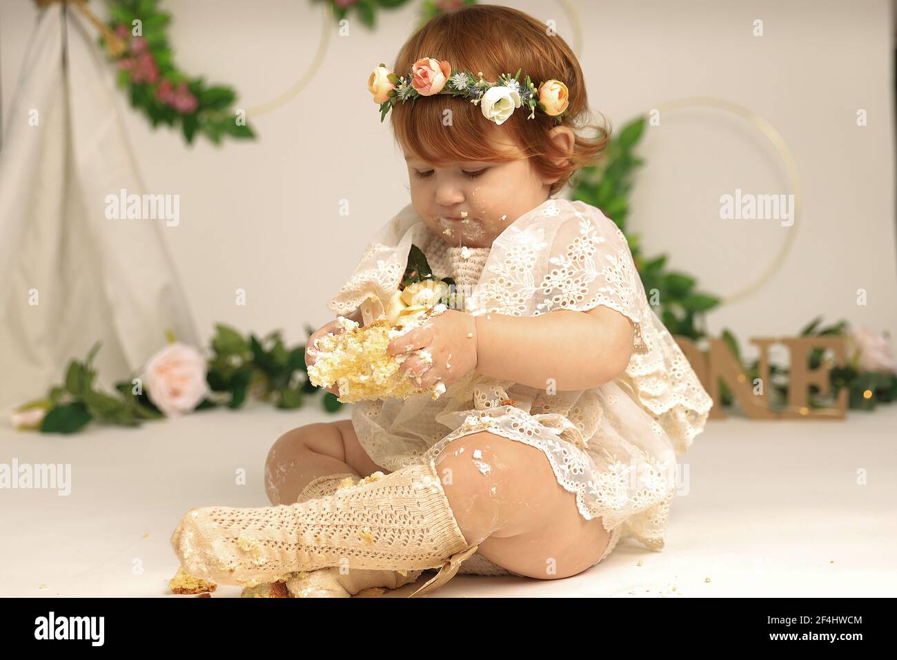 little girl smashes a cake on his first birthday. Smash cake, stylized photo session for a children's party Stock Photo