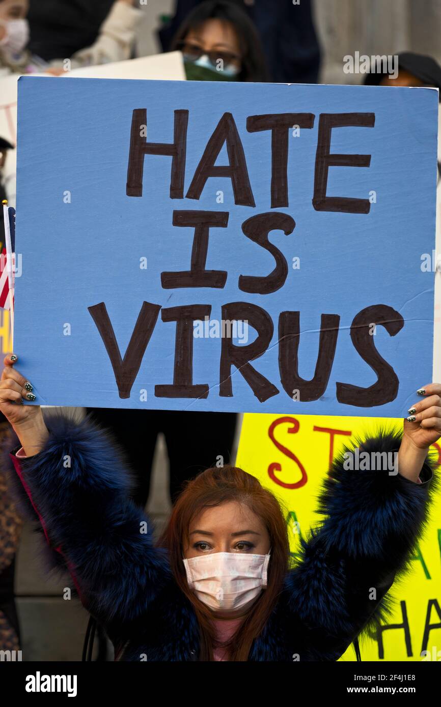 Brooklyn, New York, USA. 21 March 2021 Woman on steps of Brooklyn Borough Hall holds sign reading 'Hate is Virus' during rally against violence and discrimination after recent attacks against Asian-Americans in New York City and across the U.S. during COVID-19 pandemic. Credit: Joseph Reid/Alamy Live News Stock Photo