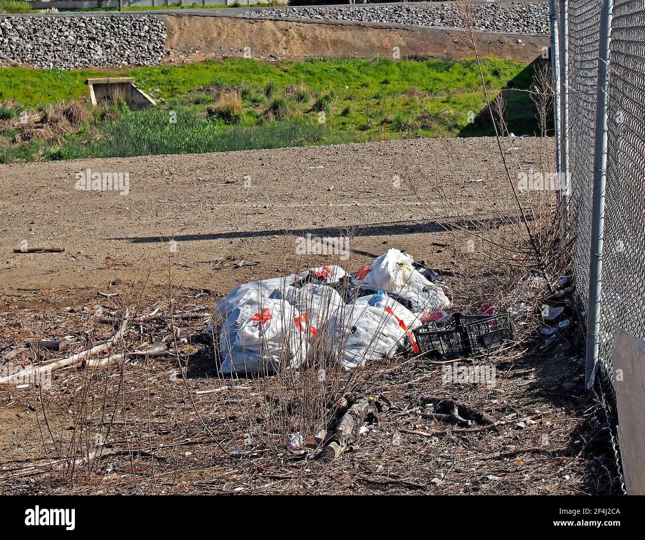 bags of trash dumped next to the Alameda Creek Trail and 880 highway in Union City, California Stock Photo