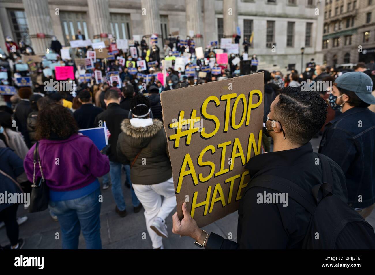 Brooklyn, New York, USA. 21 March 2021 Man holds 'Stop Asian Hate' sign during rally against violence and discrimination after recent attacks against Asian-Americans in New York City and across the U.S. during the COVID-19 pandemic. Credit: Joseph Reid/Alamy Live News Stock Photo
