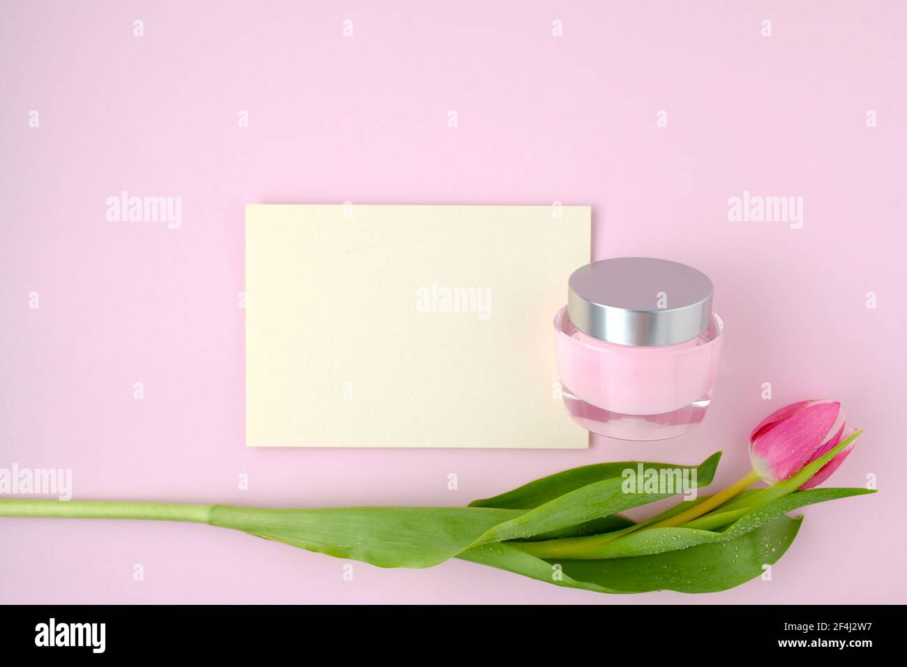 spring flat lay with tulip, paper sheet and facial creme isolated on ...