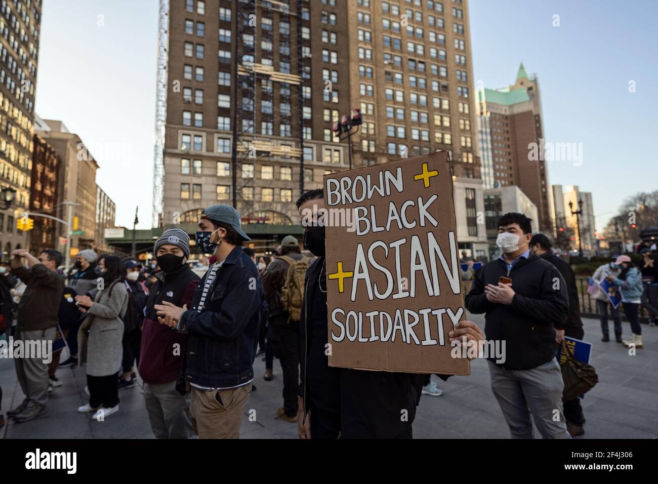 Brooklyn, New York, USA. 21 March 2021 Man in crowd holds sign calling for brown, black and Asian solidarity during rally against violence and discrimination after recent attacks against Asian-Americans in New York City and across the U.S. during the COVID-19 pandemic. Credit: Joseph Reid/Alamy Live News Stock Photo