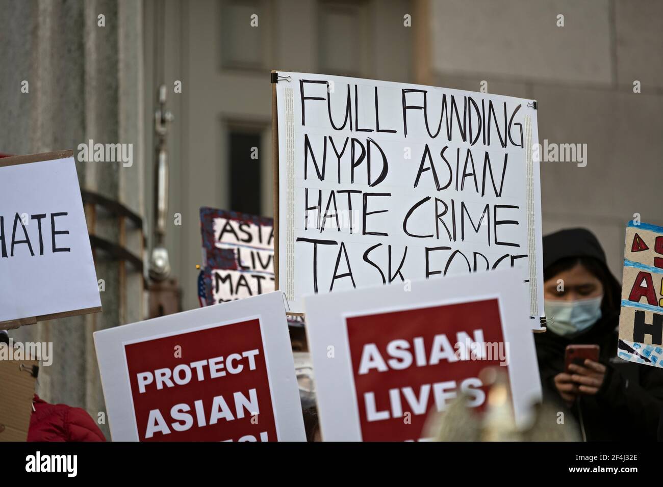 Brooklyn, New York, USA. 21 March 2021 Sign calling for full funding of NYPD Asian hate crime task force is held aloft during anti-Asian violence rally on steps of Brooklyn Borough Hall after recent attacks against Asian-Americans in New York City and across the U.S. during the COVID-19  pandemic. Credit: Joseph Reid/Alamy Live News Stock Photo