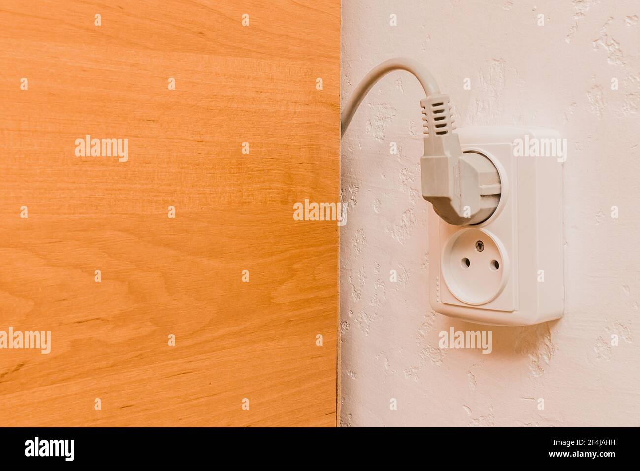 Two plugs in the socket in a modern interior. Safe connection of