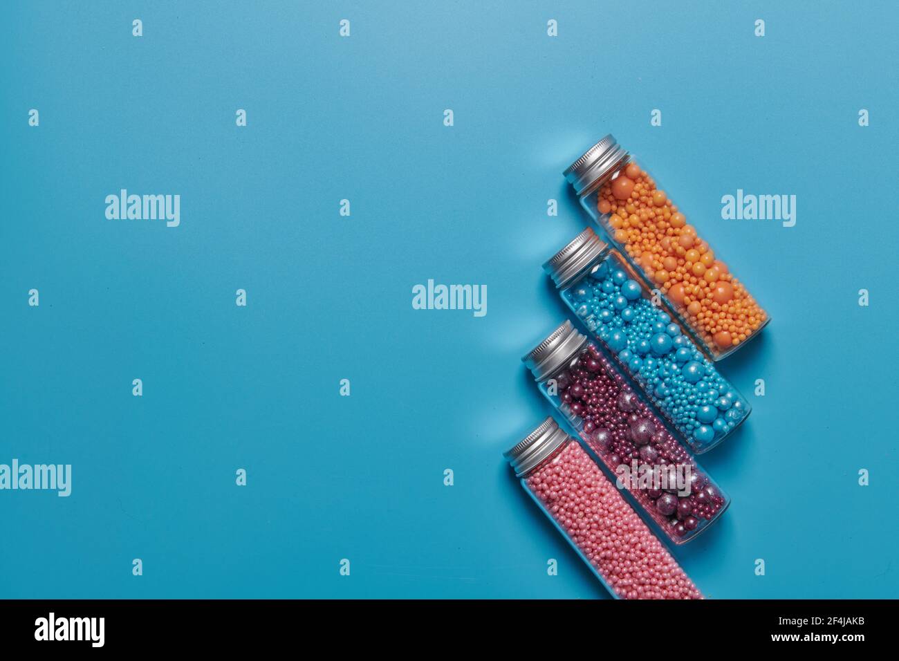 jars and colored balls on a blue background Stock Photo