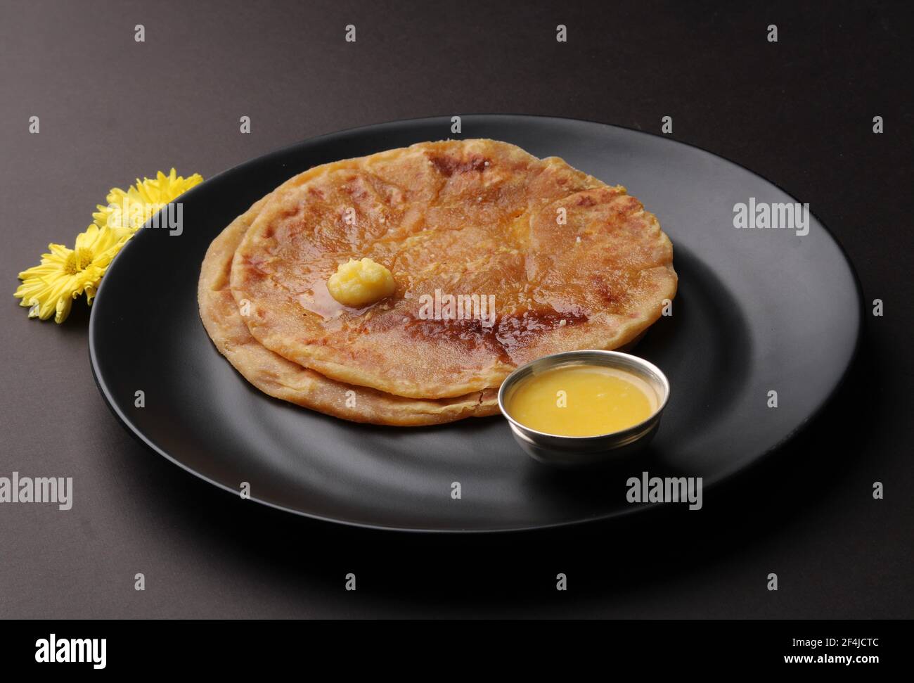 Puran Poli, also known as Holige, is an Indian sweet flatbread from India consumed mostly during Holi festival. Served in a plate with pure Ghee. Stock Photo