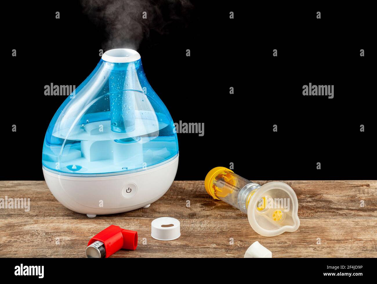 asthma, allergy airway problem, pulmonary disorders concept with ultrasonic tabletop humidifier creating steam. Inhaler and chamber mask to deliver em Stock Photo