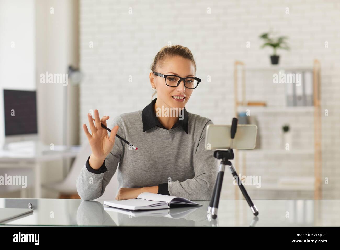 Remote teacher or business coach saying hello to her students in a virtual lesson Stock Photo