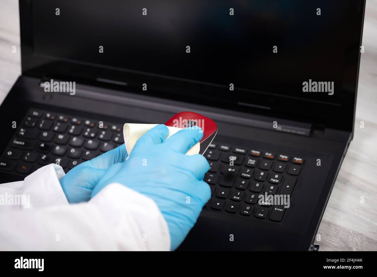 Office sanitizing wiping mouse with disinfectant. Coronavirus COVID19 sanitize cleaning