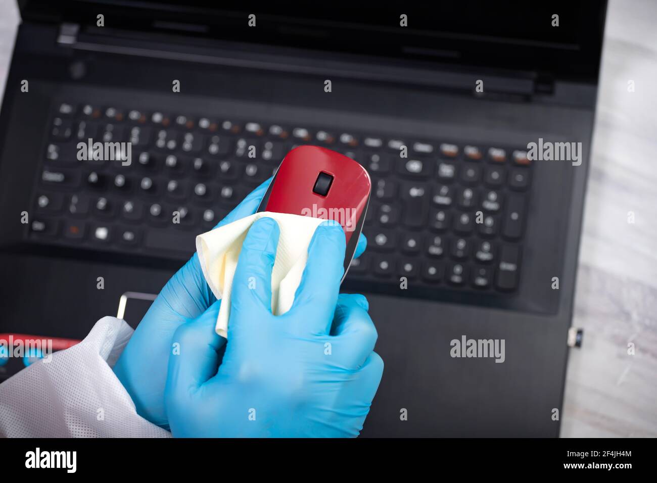 Office sanitizing wiping mouse with disinfectant. Coronavirus COVID19 sanitize cleaning