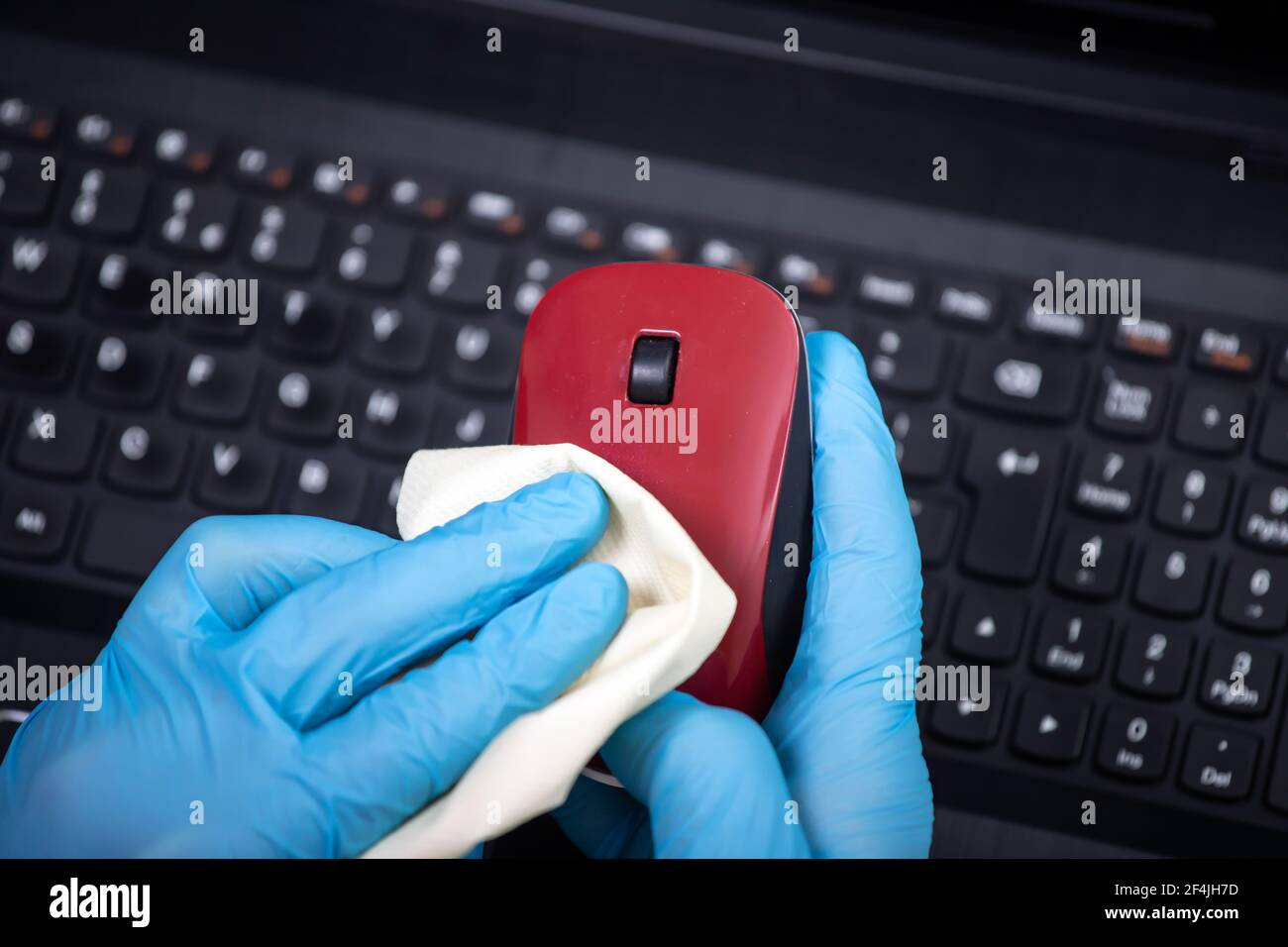 Office sanitizing wiping mouse with disinfectant. Coronavirus COVID19 sanitize cleaning