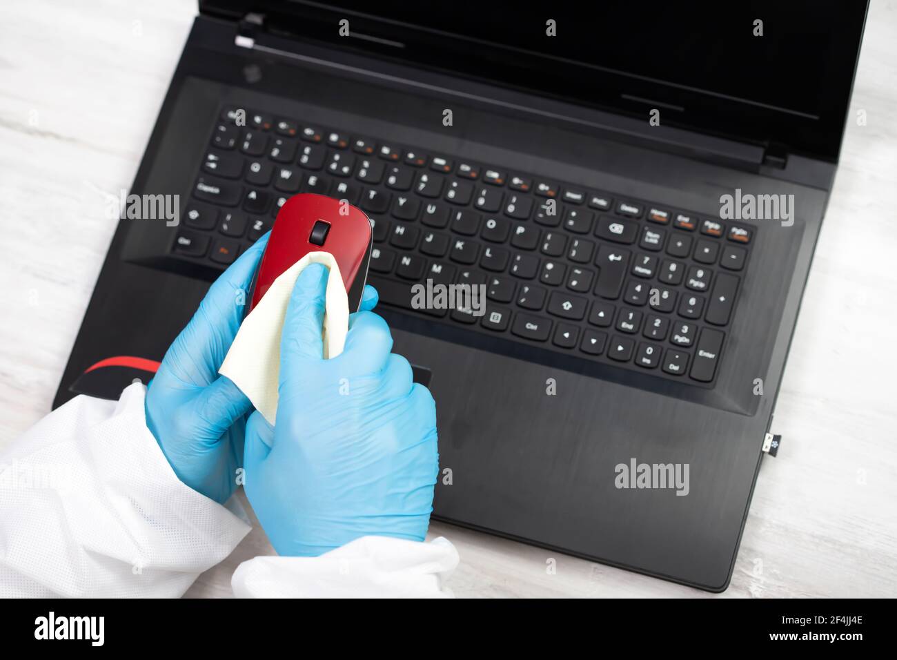 Office sanitizing wiping mouse with disinfectant. Coronavirus COVID19 sanitize cleaning