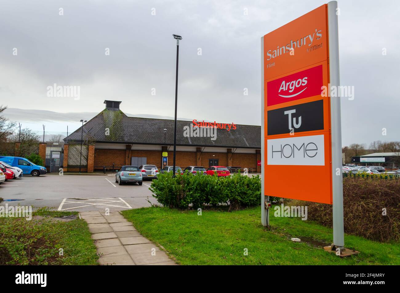 Flint; UK: Jan 28, 2021: Signage beside a Sainsbury's supermarket shows some of the instore brands, including Argos who recently relocated to inside t Stock Photo