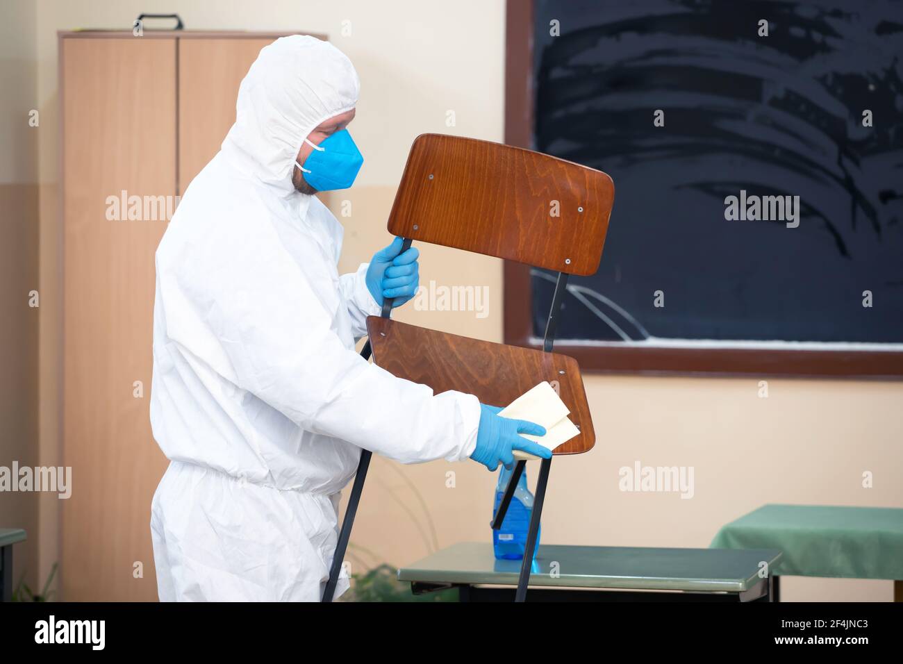 Worker sprays disinfectant as part of preventive measures against the