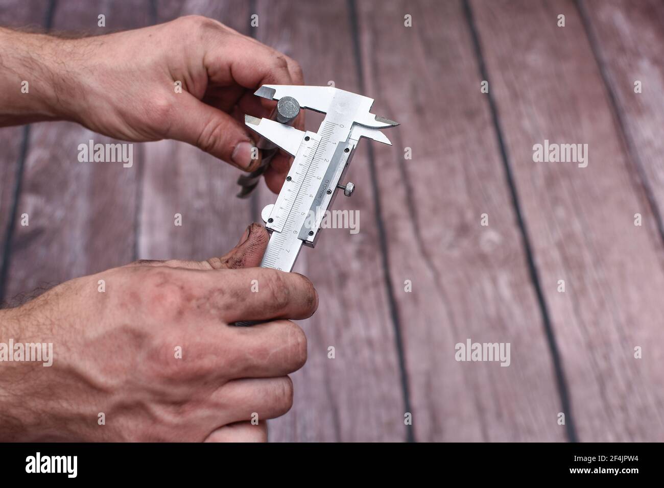 Measuring the drill diameter with a caliper.  Stock Photo