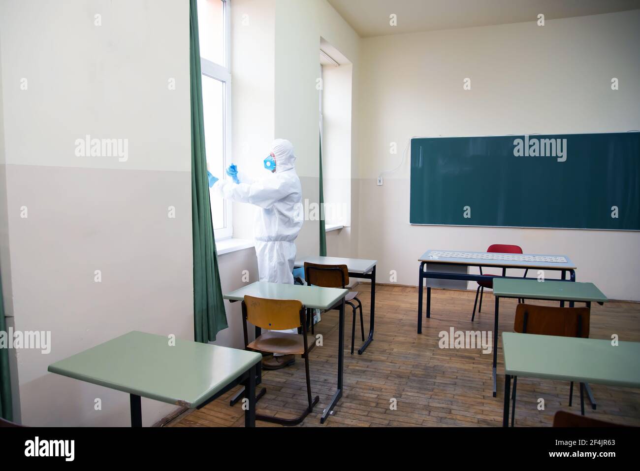 Worker sprays disinfectant as part of preventive measures against the