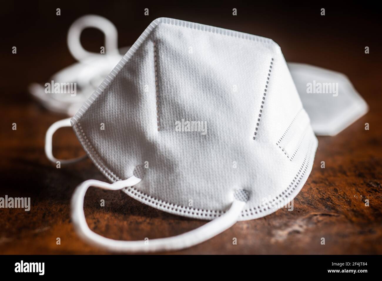 KN95 respirator mask for coronavirus protection. Face mask protects against covid-19 infection on wooden table. Stock Photo