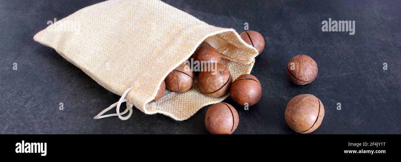 Organic Macadamia nut on dark table Stock Photo