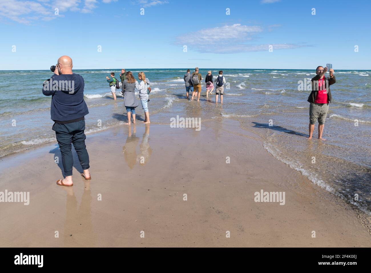 Skagen, Denmark - August 31, 2020: At Grenen, the northernmost point of Denmark, where Baltic Sea and North Sea waves meet, tourists are taking photos Stock Photo