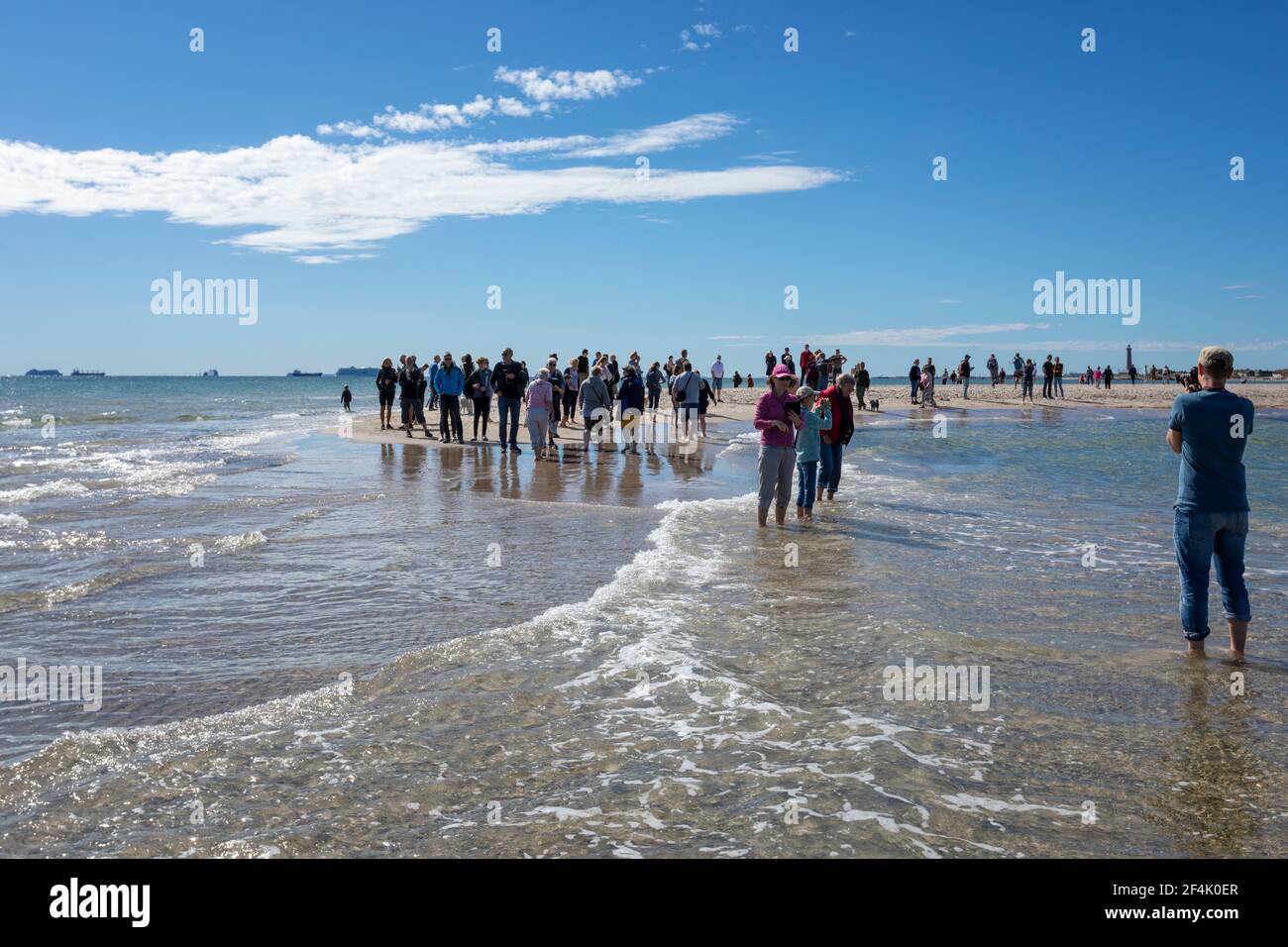 Skagen, Denmark - August 31, 2020: Photo of tourists at Grenen, northernmost point of Denmark, taken standing with one foot in the Baltic Sea and the Stock Photo