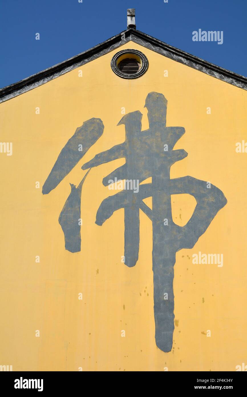 The Chinese character 'fo' which means Buddha, written on the side of a temple in China. Stock Photo