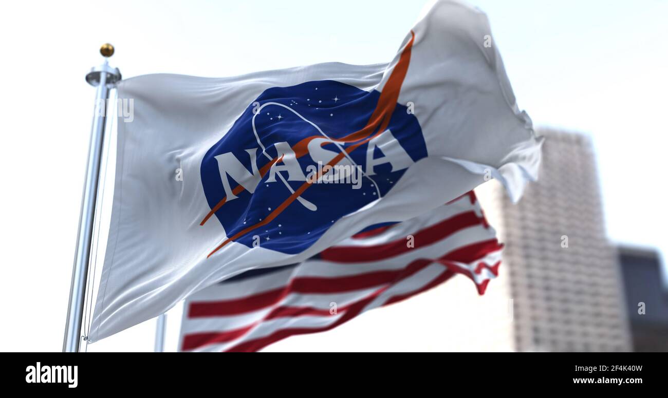 Washington, USA, March 5, 2021: The NASA flag waving along with the American flag in the background. American Space Agency. Space research and technol Stock Photo