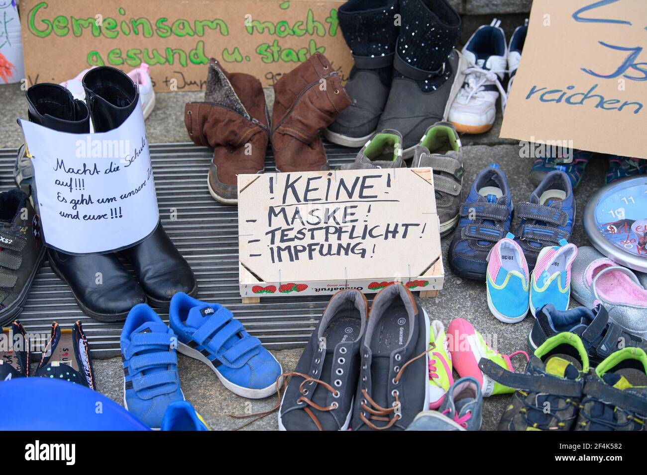 Radebeul, Germany. 22nd Mar, 2021. Numerous shoes and posters with slogans  against the school closures can be seen in front of the entrance to the town  hall. In protest against the renewed